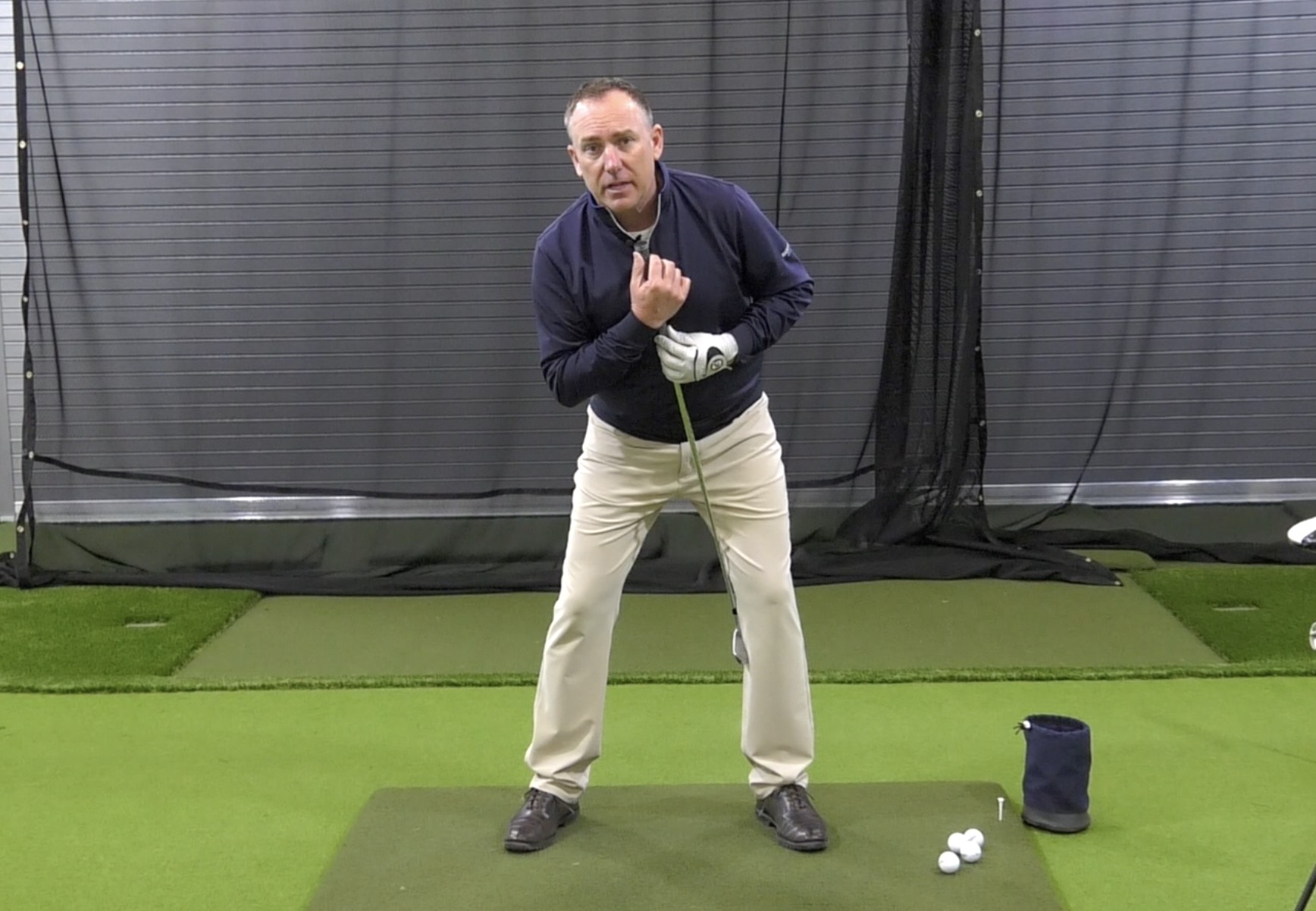 A golfer standing while inside the training area