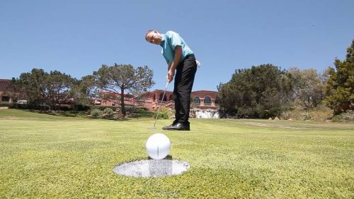 golf putt with ball rolling into cup